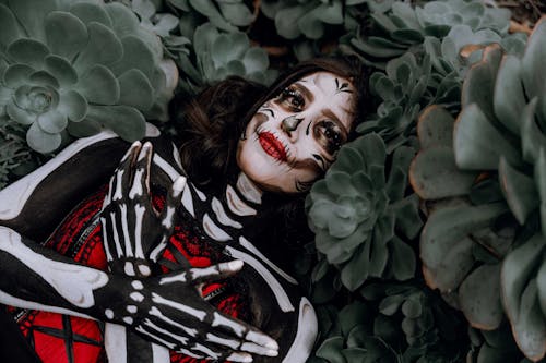 A Woman in a Skeleton Costume Lying Between Plants