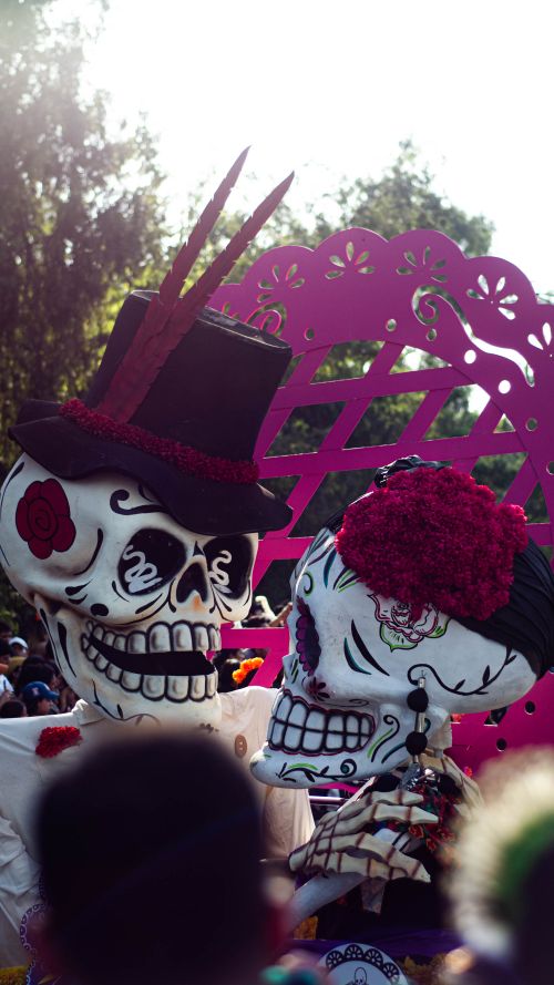 Free Colorful skulls and flowers at a festive Dia de Muertos parade outdoors. Stock Photo