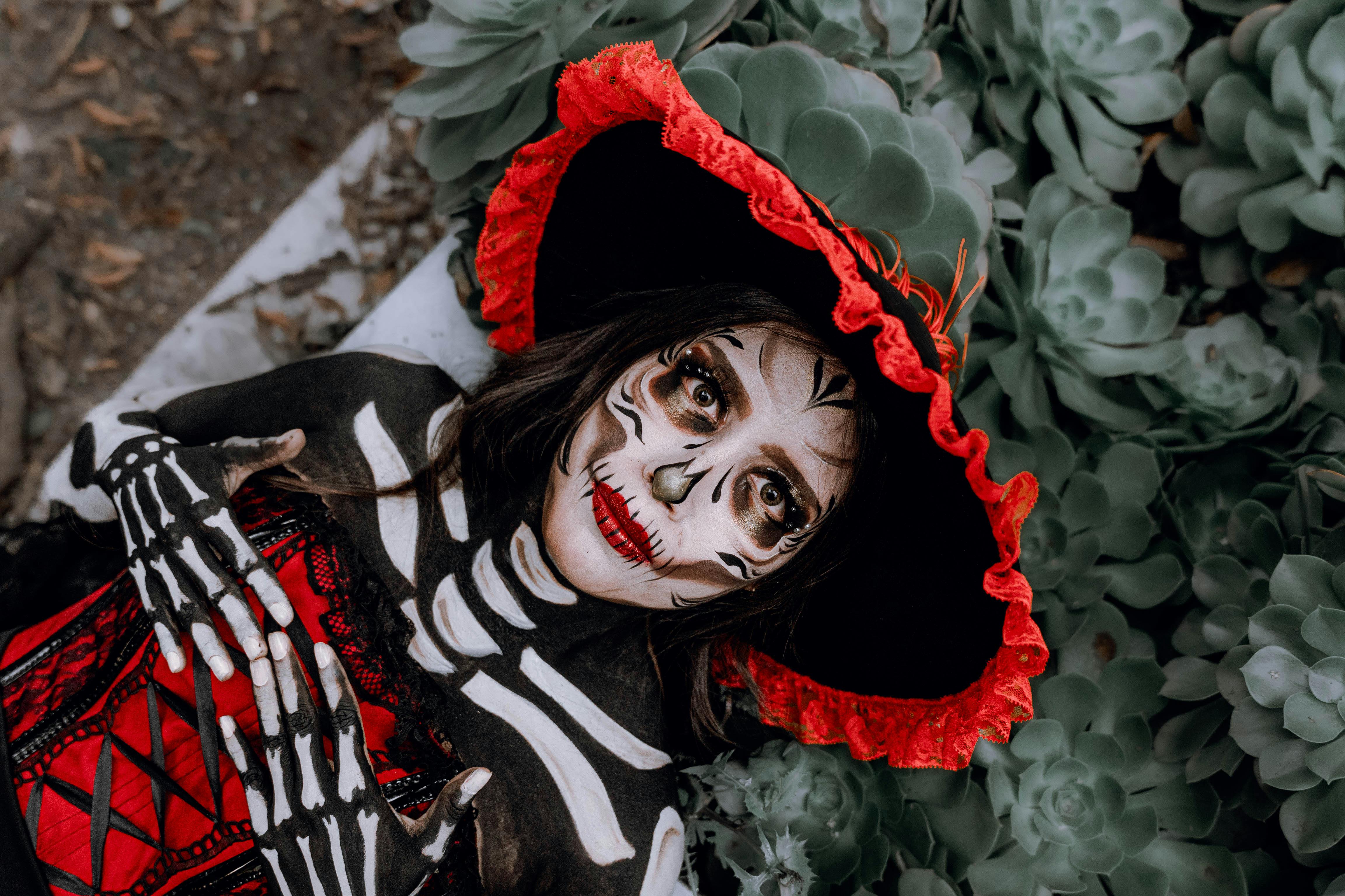 woman wearing halloween costume lying above plants