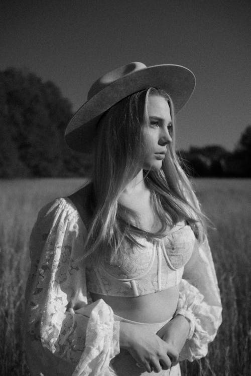 Free Woman in Hat on Rural Field in Black and White Stock Photo