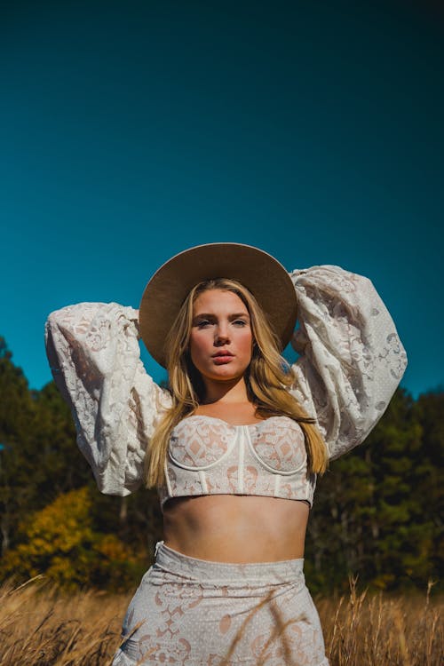 Blonde Woman in Hat and White Clothes on Field