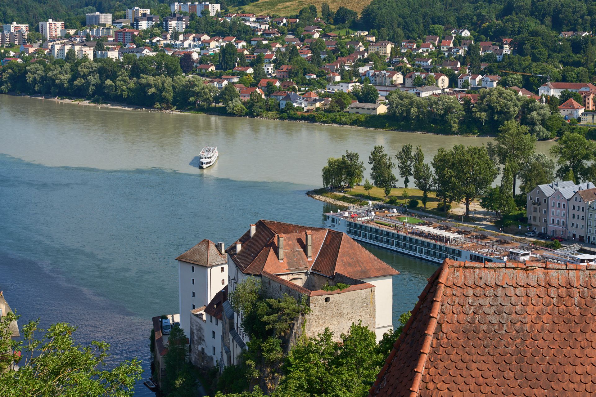 Stunning aerial view of the confluence of three rivers in Passau, Germany, with historic architecture and lush greenery.