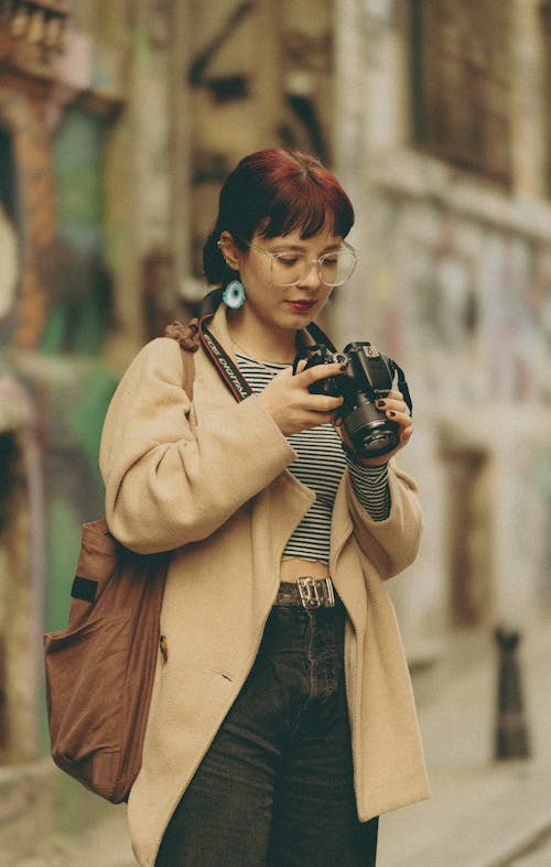 Woman in Jacket Standing and Looking at Camera