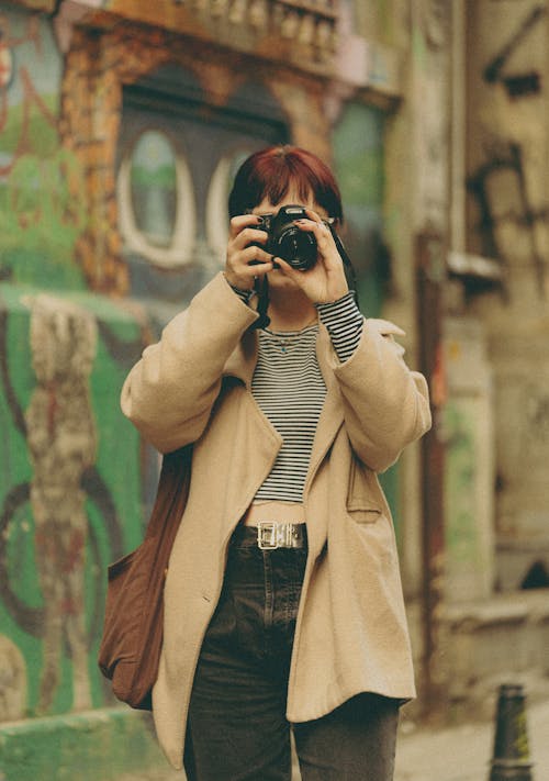 Woman in Jacket Taking Pictures with Camera
