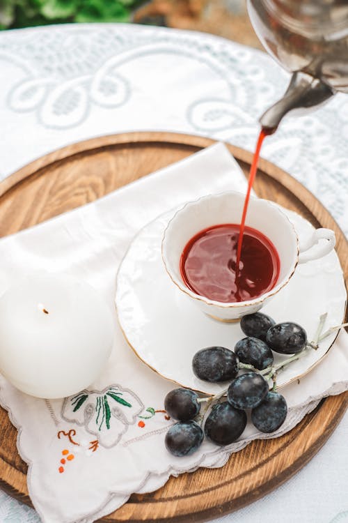 Person Pouring Tea into a Cup 