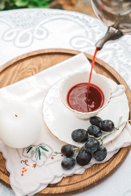 Person Pouring Tea into a Cup