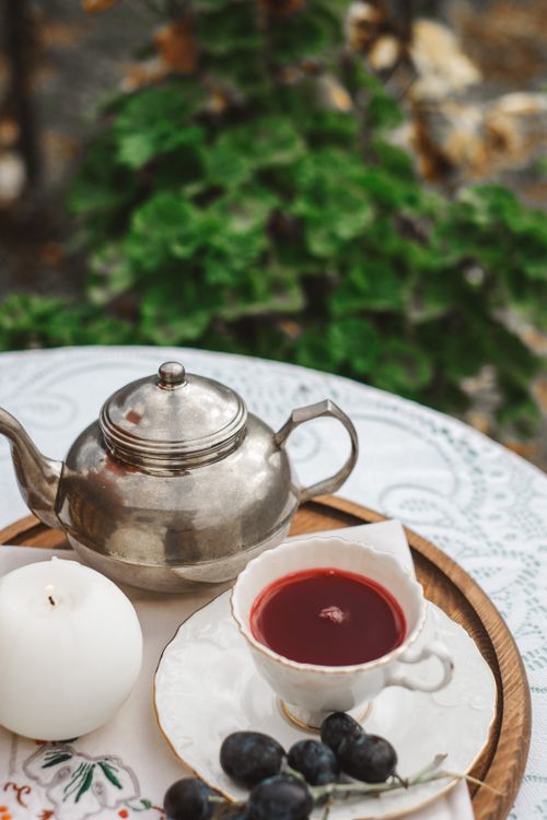 Free Vintage teacup and teapot on tray with grapes, outdoors. Stock Photo