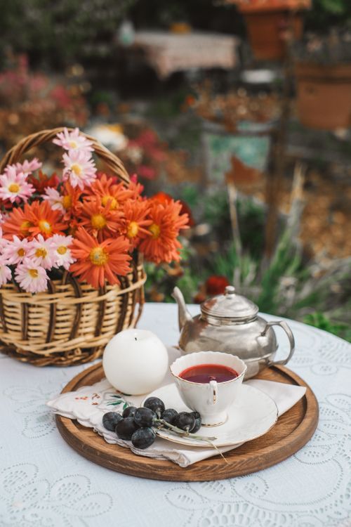 Free Charming tea setup with flowers and candle on a garden table, perfect for a serene afternoon. Stock Photo