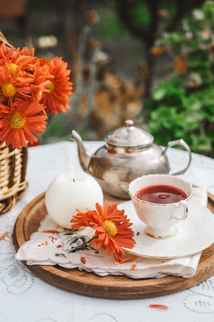 Captivating outdoor tea setup with vibrant flowers and an elegant teapot.