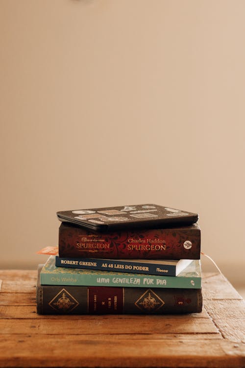 A Pile of Books Lying on a Wooden Surface 