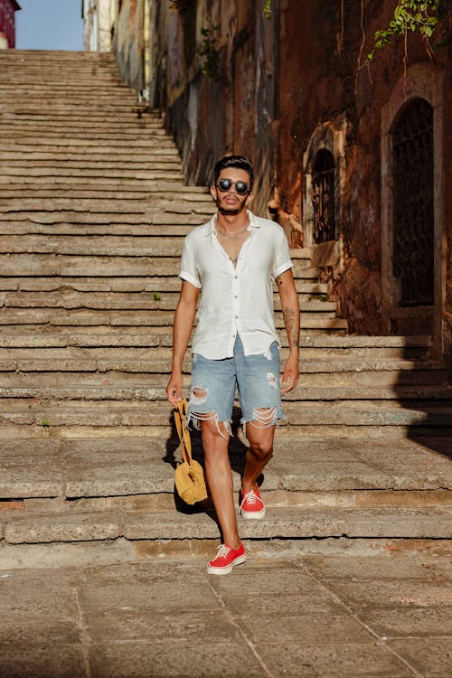 Man Walking on Steps between Old Buildings 