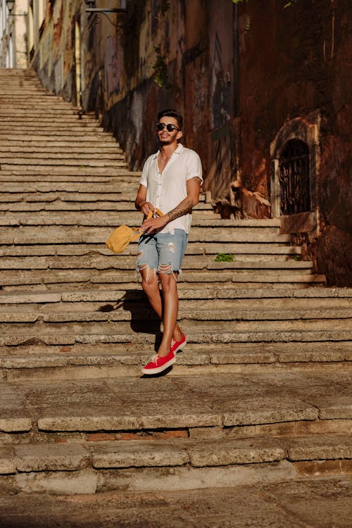 Man Walking on Steps between Old Buildings 