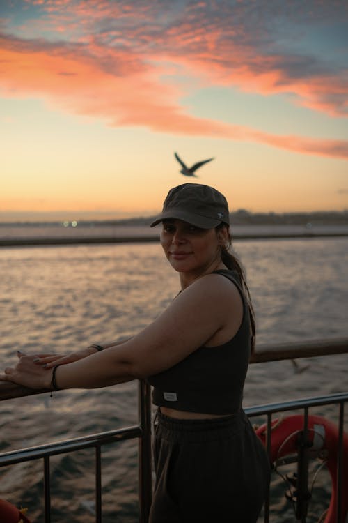 Woman in Black Top Posing on Seashore at Dusk