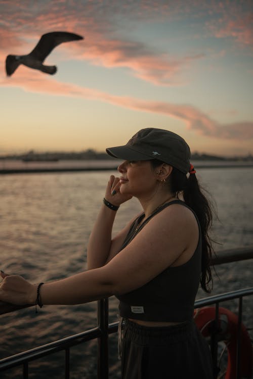 Young Woman Standing on a Pier at Sunset 