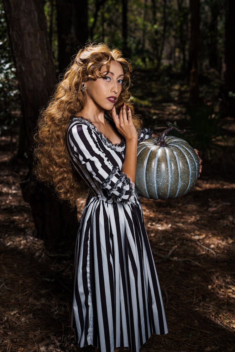 Portrait Of Woman Holding Silver Pumpkin In A Forest