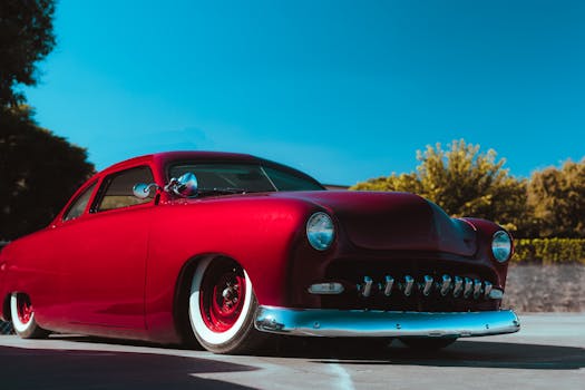 Classic red Ford from 1949 in bright sunlight, showcasing vintage elegance.