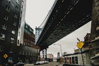 城市景观变幻莫测，头顶上横跨一座大桥，四周环绕着现代建筑