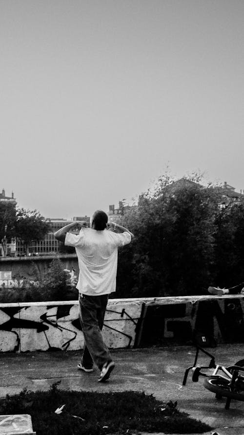 A Man in a White T-Shirt Against a Graffiti Wall