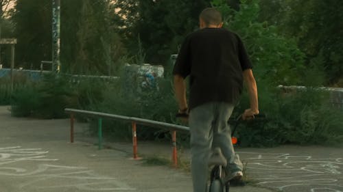 Man in T-shirt Riding Bike for Stunts
