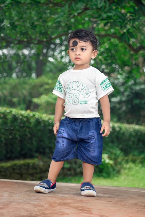 A Little Boy Standing in a Park 