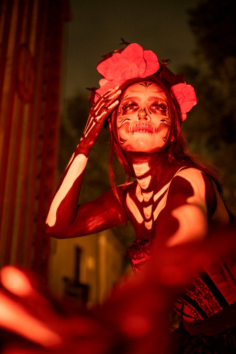 Woman Dressed As A Catrina Sitting Outside 