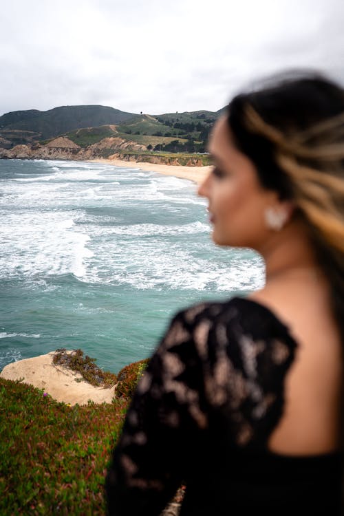 Woman in Black Dress and Waves on Sea Shore behind