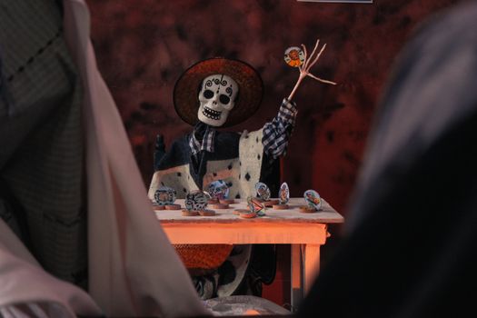 Vibrant skeleton figurine celebrates Dia de los Muertos with decorated sugar skulls.