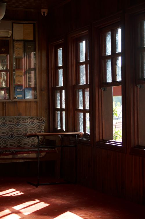 Free A cozy rustic interior featuring sunlit wooden windows and a patterned bench, perfect for serene moments. Stock Photo