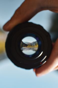Dramatic focus on mountain landscape through camera lens, handheld outdoors.
