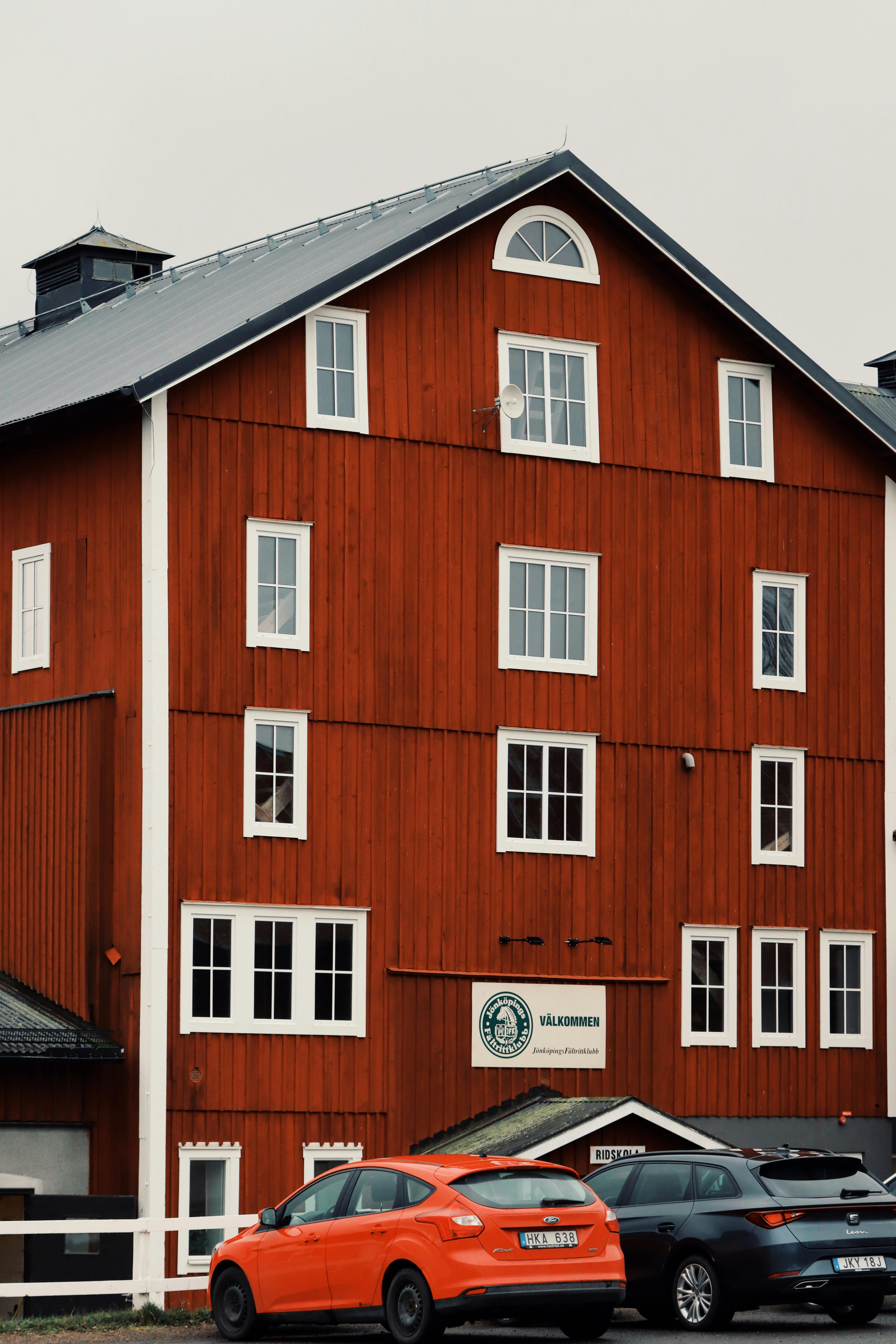 Charming red wooden building with parked cars in Jönköping, Sweden. Represents Scandinavian architecture.