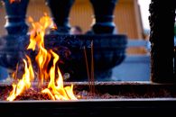 Close-up of incense sticks burning with vibrant flames at a temple.
