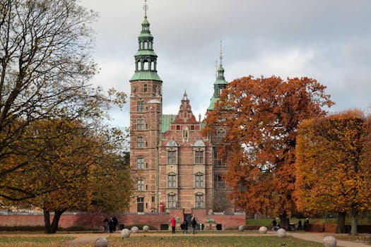 Explore the historic beauty of Rosenborg Palace surrounded by vibrant autumn foliage.