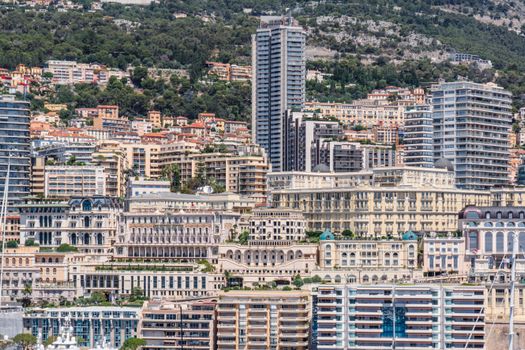 A detailed view of Monaco's luxurious buildings and skyline against a lush hillside.
