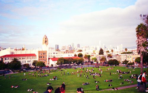 Free People enjoying a sunny day at Dolores Park with San Francisco skyline views. Stock Photo
