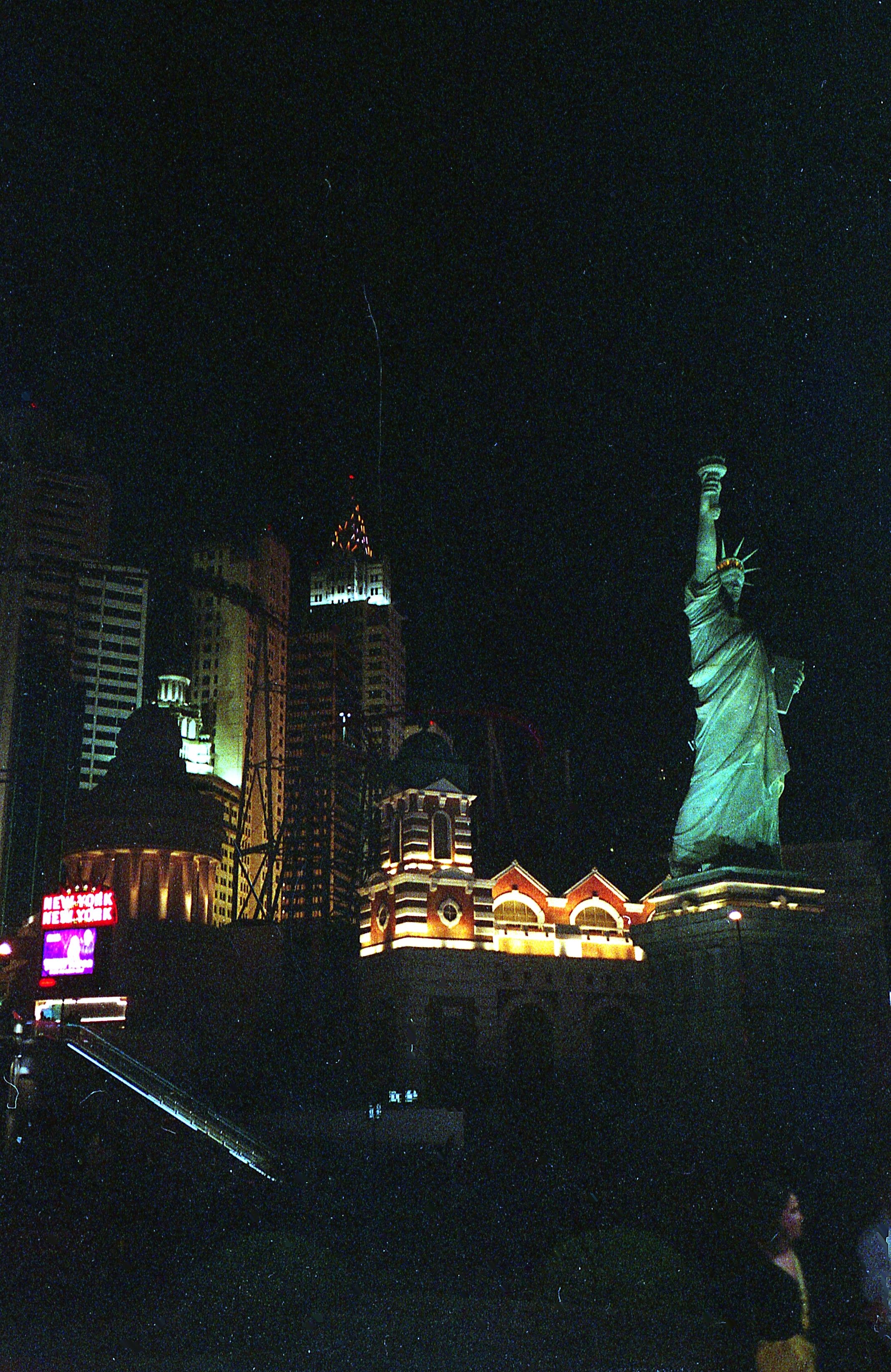 Illuminated Las Vegas skyline featuring a replica Statue of Liberty at night.
