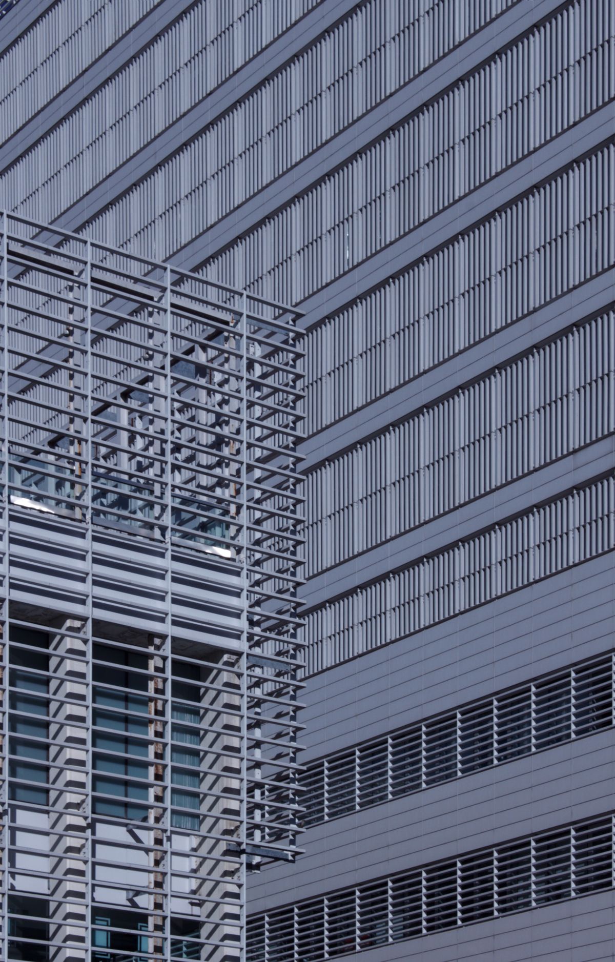 Fachada de edifício contemporâneo com linhas verticais, vidro e luz natural