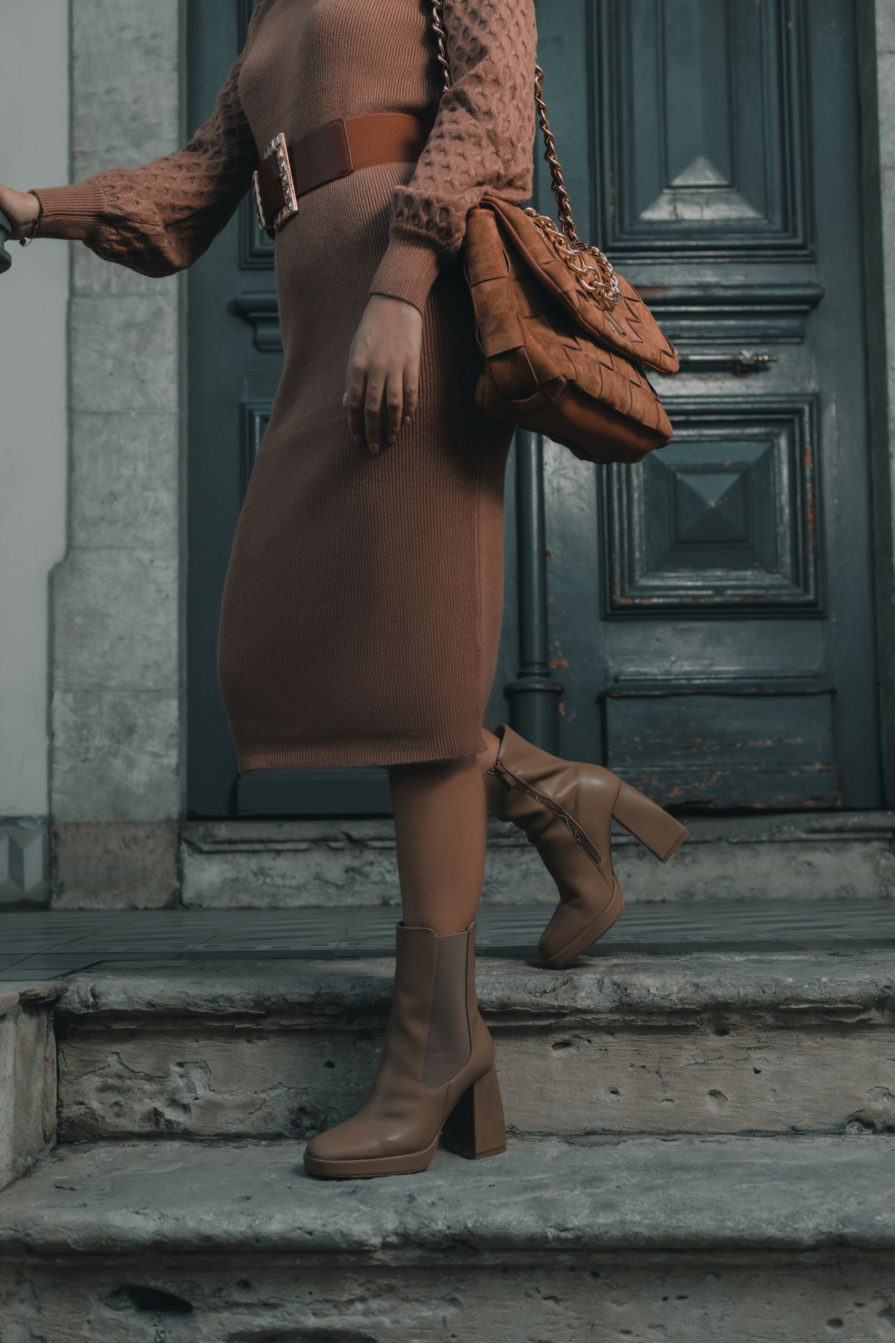 Brown ribbed knit midi dress with a wide belt and tan ankle boots