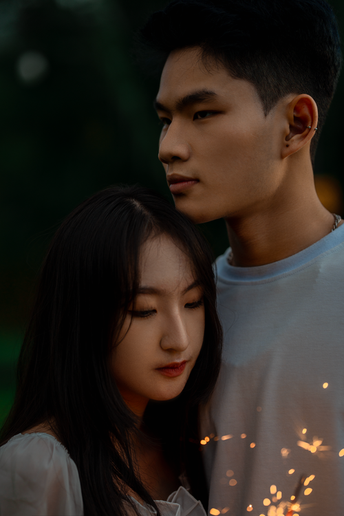 Free Young couple embracing tenderly in the soft glow of twilight sparks, Dalat, Vietnam. Stock Photo