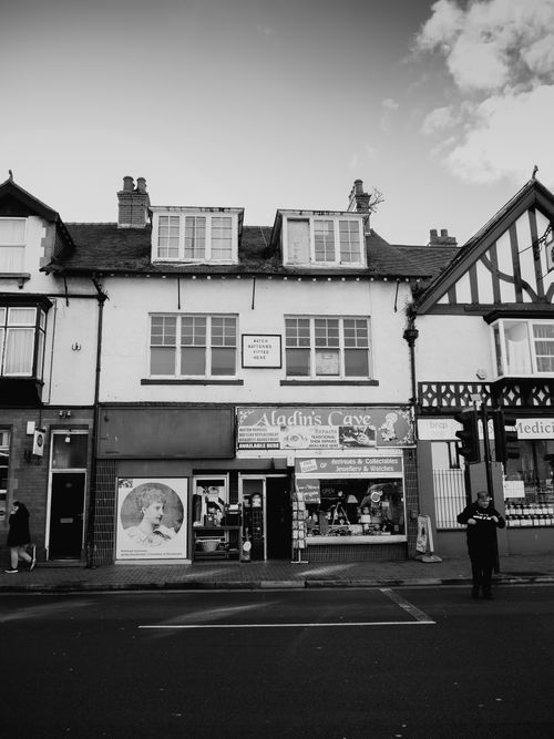 Free Monochrome image of urban street showcasing historic shopfronts and architecture. Stock Photo