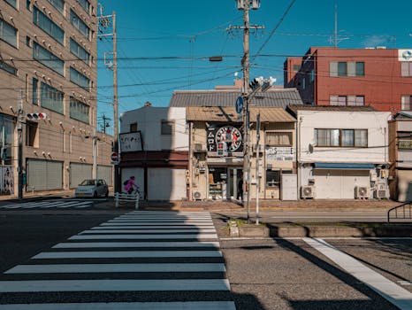 Cyclist traversing a crosswalk in Nagoya, showcasing city life and architecture.