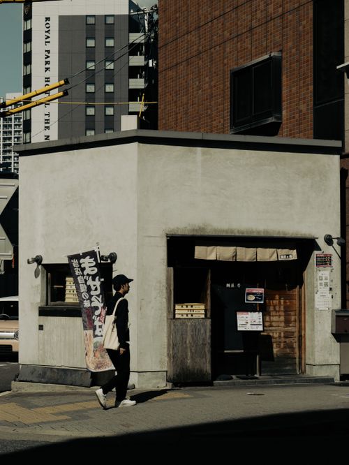 Free Man walking past a traditional-style building in Nagoya, Japan's urban setting. Stock Photo