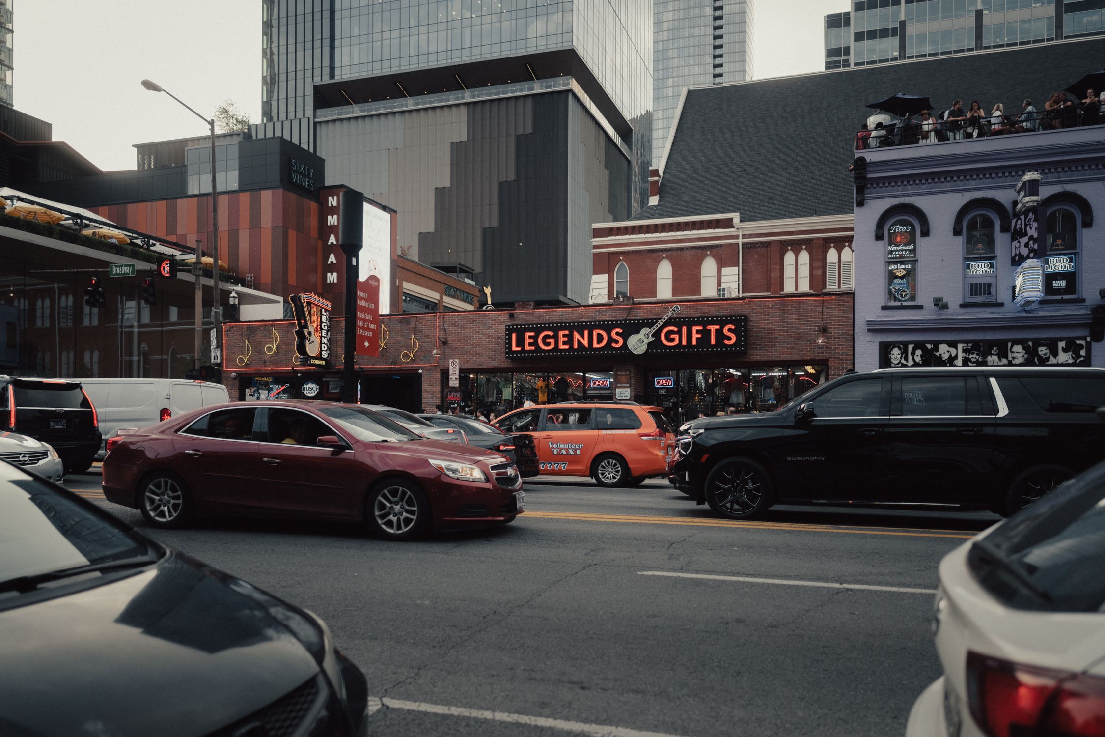 Dynamic city street view in Nashville with colorful buildings, cars, and bustling activity