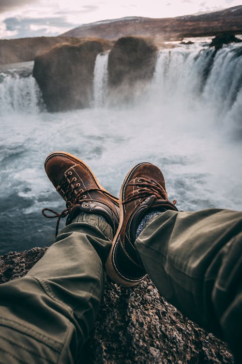 Free Person Sitting on Rock Near Waterfalls Stock Photo