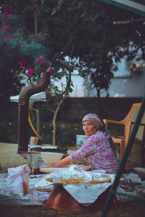Free Elderly woman preparing dough outdoors in a garden during summer. Stock Photo