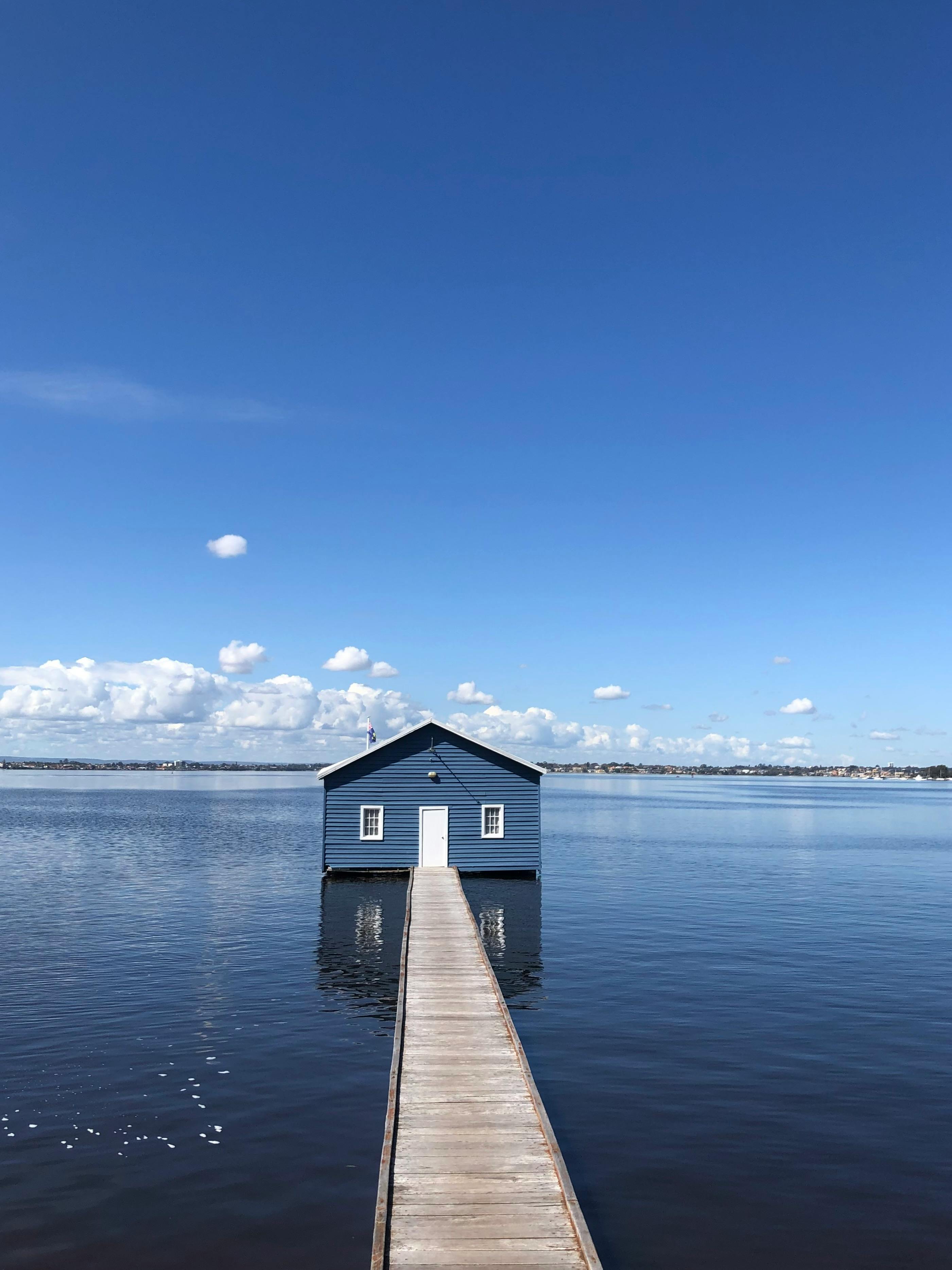 Charming blue boathouse on Swan River, capturing serene landscapes of Crawley, WA.