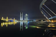 令人惊叹的夜间城市景观中，桥梁和摩天大楼倒映在河面上