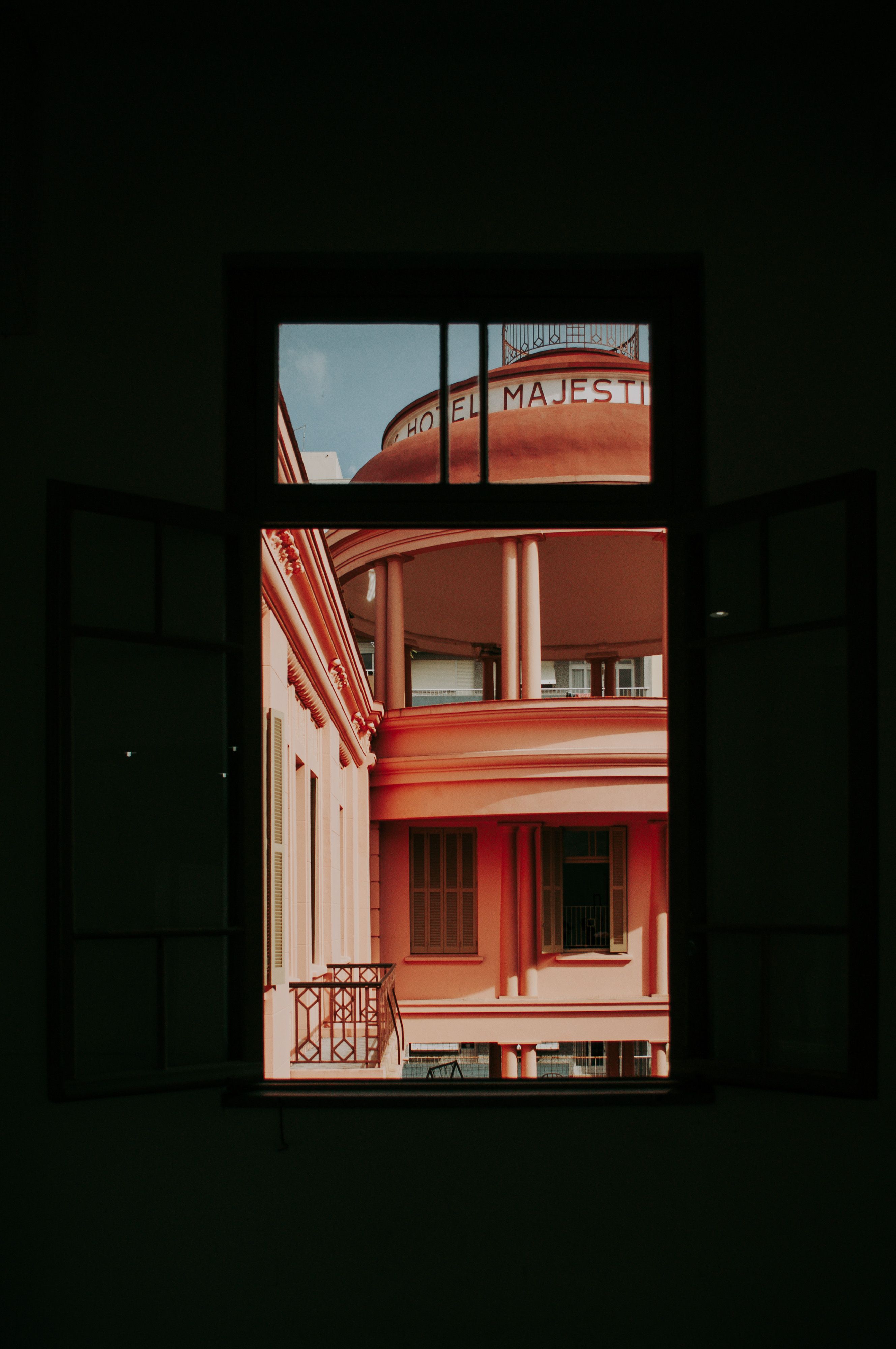 A stunning view of the art deco architecture of Hotel Majestic through an open window, highlighting its elegance.