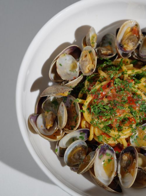 Free Close-up of a delicious seafood pasta dish with clams, garnished with fresh herbs. Stock Photo