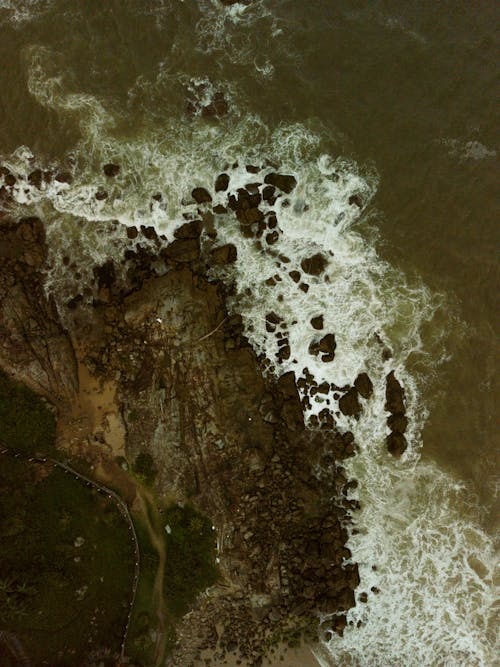 Top View of Waves Crashing on a Rocky Shore 