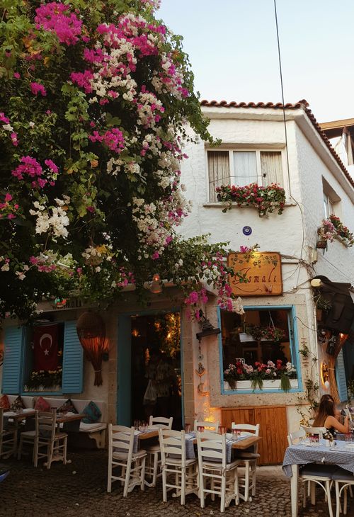 Free Colorful café with flowers and traditional decor in Alaçatı, İzmir, Türkiye. Captures vibrant street life. Stock Photo